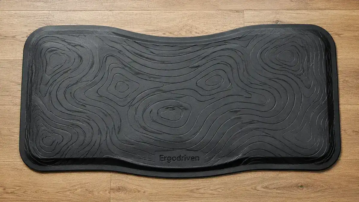 Person wiping down the surface of the Ergodriven Topo mat with a damp cloth showing the cleaning process