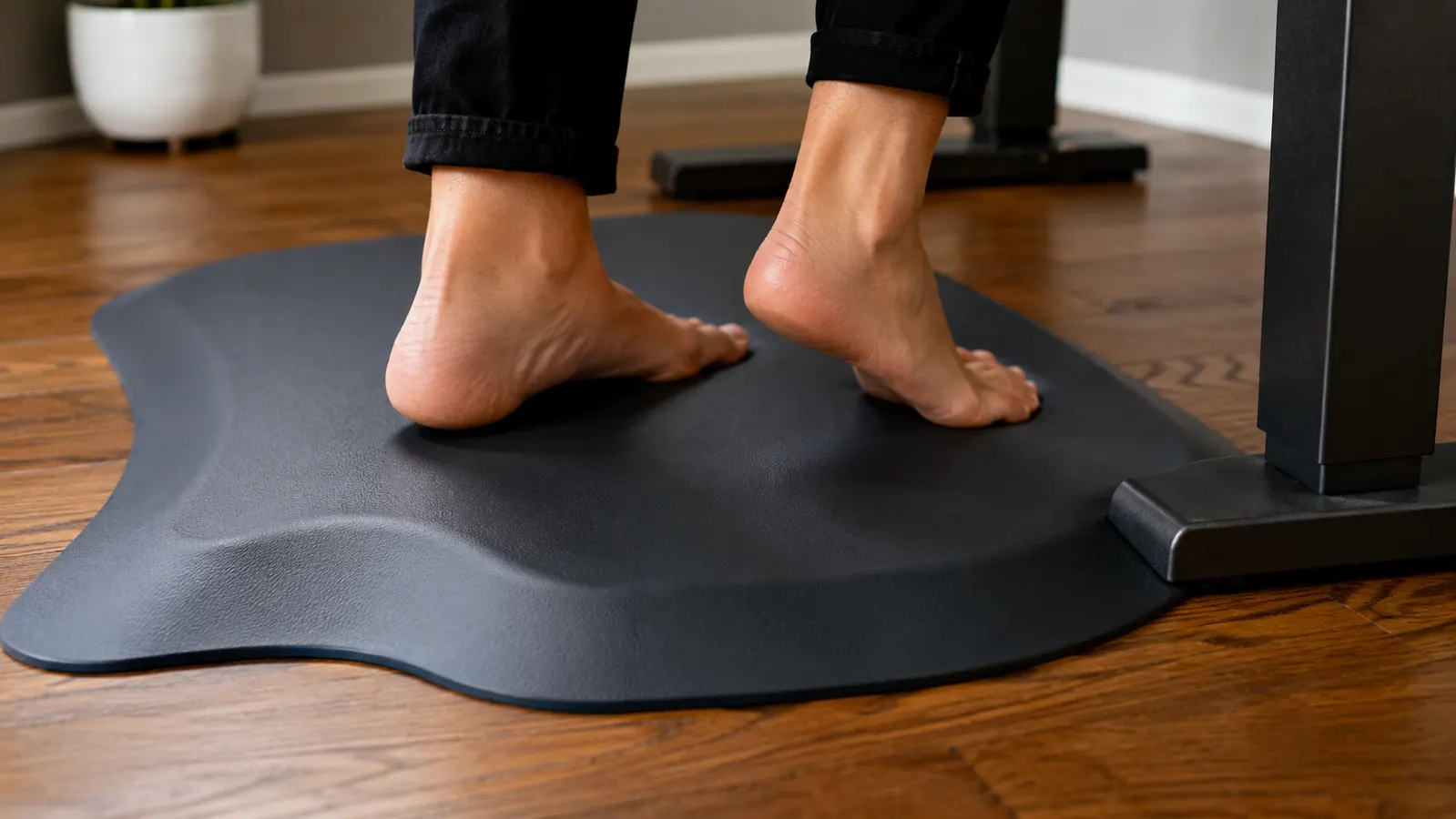 Person walking in socks across a home office from a chair to a standing desk with an anti-fatigue mat