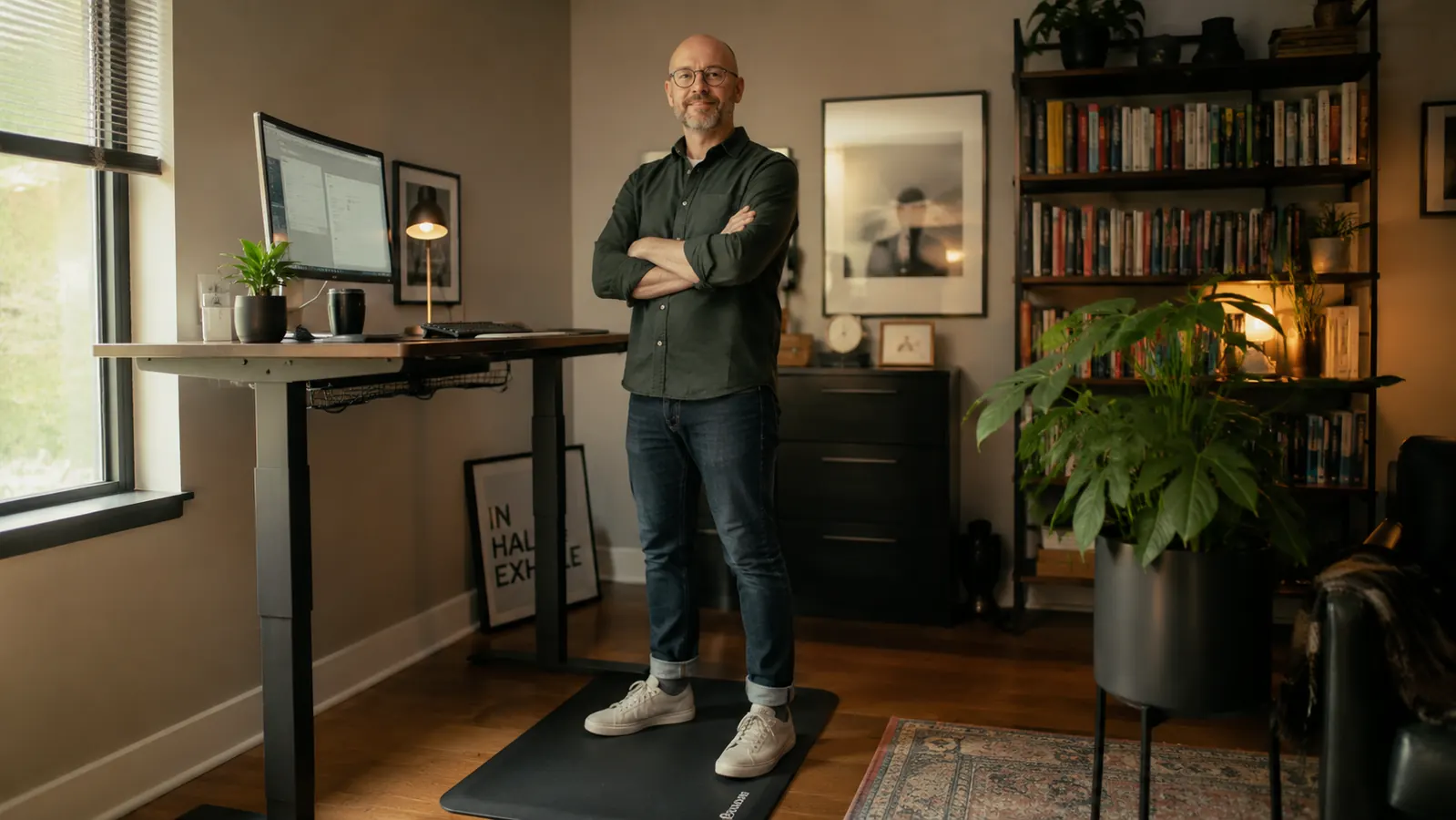 Home office standing desk setup with contoured anti-fatigue mat on hardwood floor in morning light