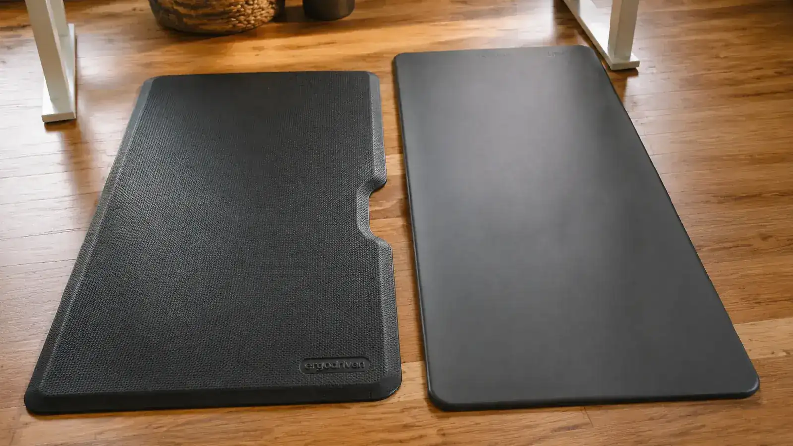 Ergodriven Topo anti-fatigue mat in a bright home office with a standing desk, showing the contoured surface and raised terrain design