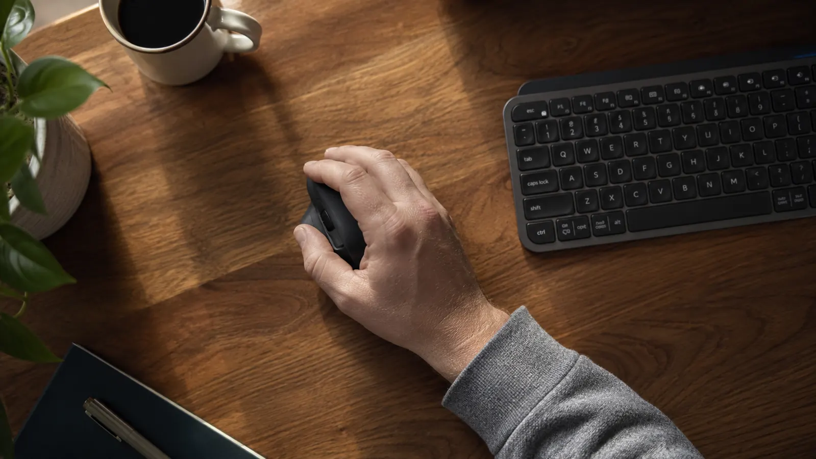 Remote worker rubbing a tired right hand at a home office desk with a standard mouse visible nearby