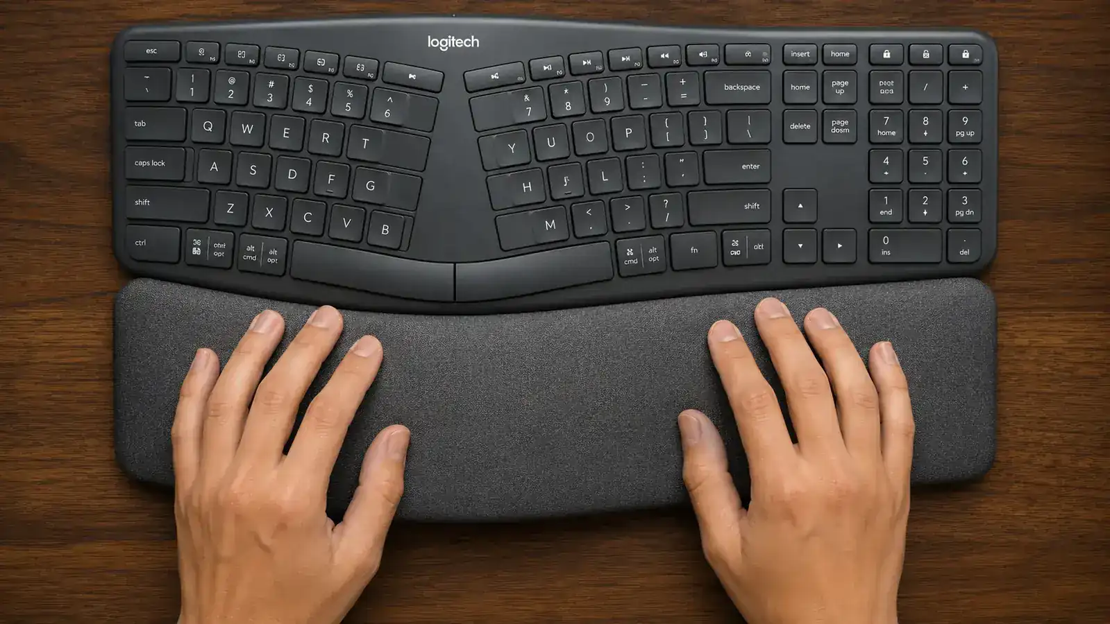Person adjusting keyboard tilt leg while looking at monitor position in a home office