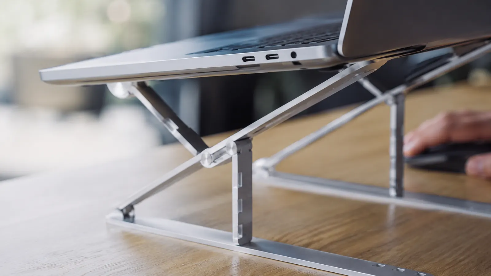 Laptop on Lamicall stand with an external keyboard and mouse on the desk surface below, showing a full ergonomic desk layout